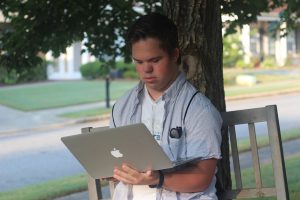 Youth with Down syndrome using a laptop.
