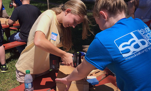 Girl with a hot glue gun working on a project