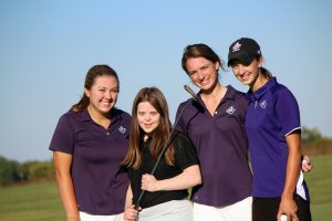 4 young women, including one young woman with Down syndrome, playing golf.